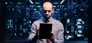 Redes de datacenters distribuídas com estratégia multisites: imagem de gestor olhando tablet dentro de data center.